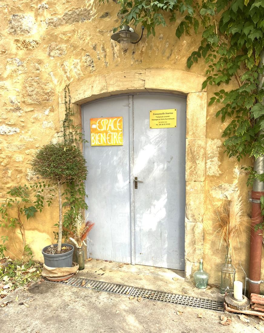 La porte de l'Espace bien-être, dans un mur de pierre dorée