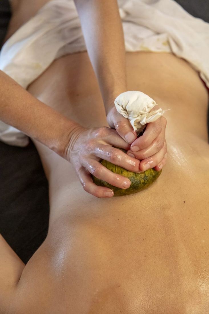 Massage aux pochons d'herbes chauds