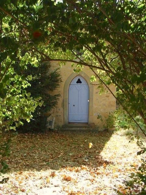 La porte gothique bleue de la chapelle, sous les branches